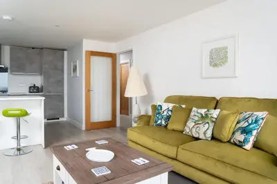 a living room with a green couch and a table at Seasky in Praa Sands