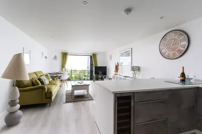 a kitchen and living room with a clock on the wall at Seasky in Praa Sands