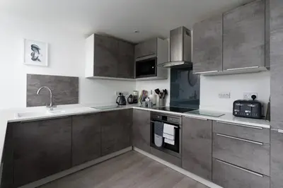 a kitchen with gray cabinets and a sink at Seasky in Praa Sands