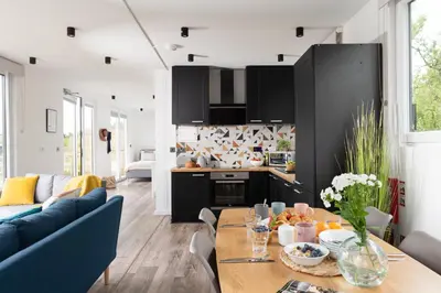 a kitchen and living room with a table and a blue couch at Trevassack Holidays in Helston