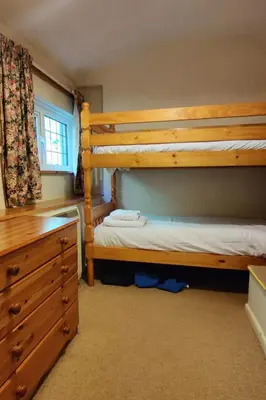 a bedroom with two bunk beds and a dresser at Holiday Home The Old Inn by Interhome in Pentewan