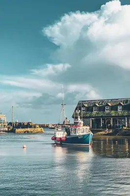 a boat sitting in the water in front of a building at Holiday Home The Old Inn by Interhome in Pentewan