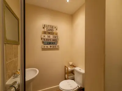 a bathroom with a white toilet and a sink at Apartment Jetty Cottage by Interhome in Mevagissey
