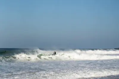 a person riding a wave on a surfboard in the ocean at Ground Floor Couples Retreat in Newquay