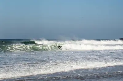 a person riding a wave on a surfboard in the ocean at Ground Floor Couples Retreat in Newquay