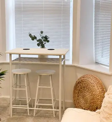 a table and stools in a room with a window at Ground Floor Couples Retreat in Newquay
