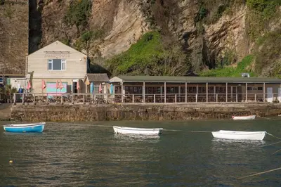 three boats in the water in front of a building at Spacious Flat Sea Views & Private Parking Fistral in Newquay