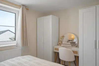a white bedroom with a mirror and a bed at Cosy Apartment Parking Central Newquay in Newquay