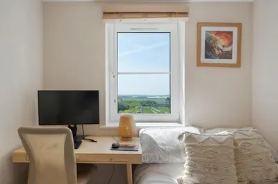 a bedroom with a desk with a computer and a window at Cosy Apartment Parking Central Newquay in Newquay