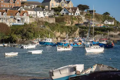 a group of boats docked in a harbor with houses at Cosy Apartment Parking Central Newquay in Newquay