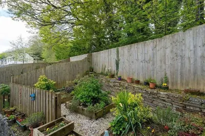 a garden with a wooden fence and some plants at Modern Townhouse in Penryn with Private Parking in Penryn