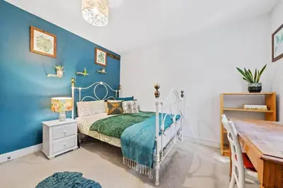 a bedroom with a bed and a blue wall at Modern Townhouse in Penryn with Private Parking in Penryn