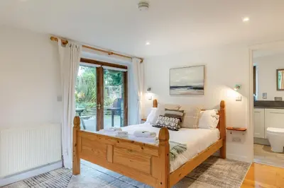 a bedroom with a bed and a large window at 4 Bed in Torpoint oc-m30122 in Downderry