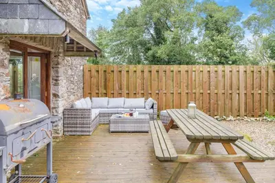 a patio with a couch and a table and a grill at 4 Bed in Torpoint oc-m30122 in Downderry