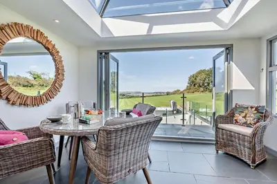 a dining room with a table and chairs and a mirror at 5 Bed in St. Issey oc-r4328 in Saint Issey