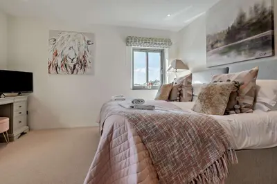 a bedroom with a large bed and a television at 5 Bed in St. Issey oc-r4328 in Saint Issey