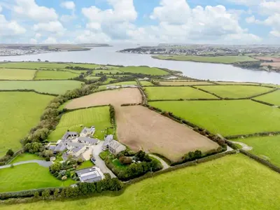 an aerial view of a house in a field next to a lake at 5 Bed in St. Issey oc-r4328 in Saint Issey