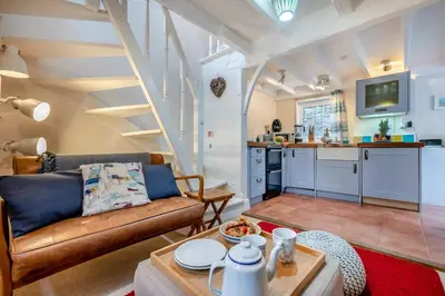 a living room with a couch and a kitchen at 1 Bed in Padstow oc-s30202 in Padstow