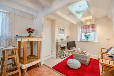 a living room with a television and a red rug at 1 Bed in Padstow oc-s30202 in Padstow