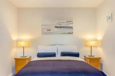 a bedroom with a large bed with two lamps at 2 Bed in Tywardreath oc-a30310 in Tywardreath
