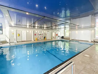 a large swimming pool with blue water in a building at 2 Bed in Tywardreath oc-a30310 in Tywardreath