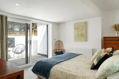 a bedroom with a bed and a balcony at Ranalegh Court in Saint Columb Minor