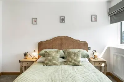 a bedroom with a bed with green and white sheets and pillows at Ranalegh Court in Saint Columb Minor