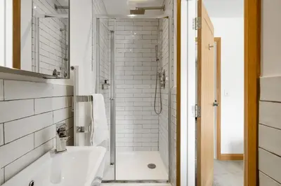 a white bathroom with a shower and a sink at Ranalegh Court in Saint Columb Minor
