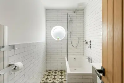 a white bathroom with a tub and a shower at Ranalegh Court in Saint Columb Minor