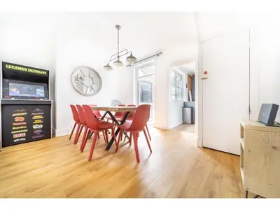 a dining room with a table and red chairs at Spacious Home Private Parking Central Newquay in Newquay