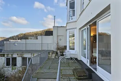 a balcony of a house with a table and chairs at Apartment Sea Views & Terrace on Waters Edge in Polruan in Polruan