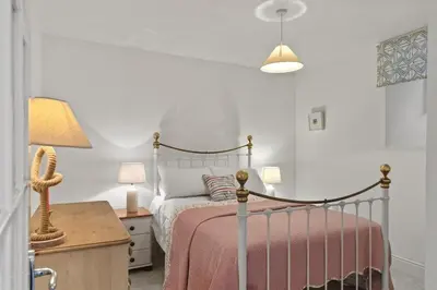a bedroom with a bed and a table with a lamp at Apartment Sea Views & Terrace on Waters Edge in Polruan in Polruan
