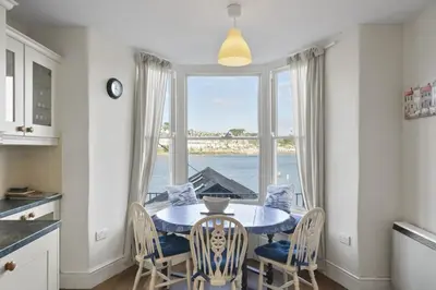 a kitchen with a table and chairs and a large window at Apartment Sea Views & Terrace on Waters Edge in Polruan in Polruan