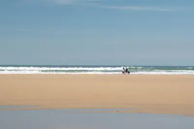 a group of people walking on the beach at Modern Apartment nr Fistral Beach Private Parking in Newquay