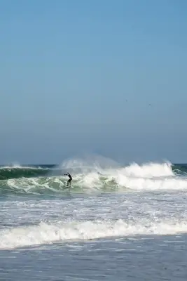 a person riding a wave on a surfboard in the ocean at Modern Apartment nr Fistral Beach Private Parking in Newquay