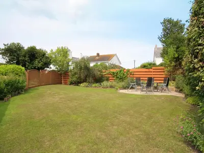 a yard with a fence and chairs in it at Curlew in Wadebridge