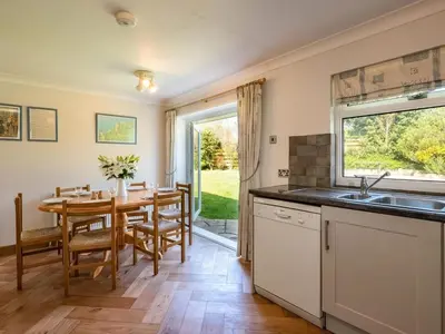 a kitchen and dining room with a table and a window at Curlew in Wadebridge
