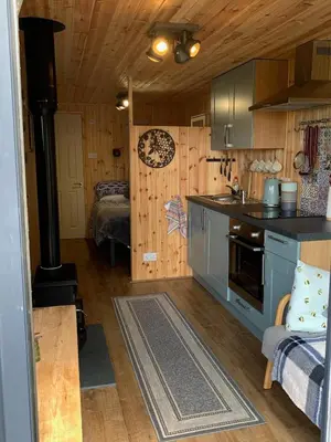 a kitchen with a stove and a room with a bed at The Lookout in Padstow