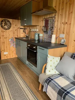 a kitchen with a stove and a couch in a room at The Lookout in Padstow