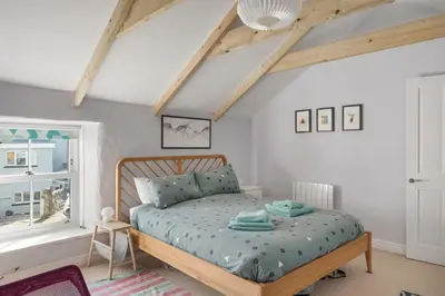 a bedroom with a bed and a window at Cornish Miners Cottage St Agnes in St. Agnes