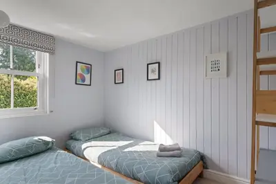 a bedroom with two beds and a window at Cornish Miners Cottage St Agnes in St. Agnes