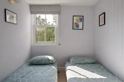 a bedroom with two beds and a window at Cornish Miners Cottage St Agnes in St. Agnes