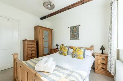 a bedroom with a large bed and wooden furniture at Large Grade II Listed House & Garden nr Beaches in Saint Columb Major