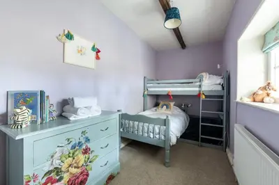 a childs bedroom with purple walls and a bunk bed at Large Grade II Listed House & Garden nr Beaches in Saint Columb Major