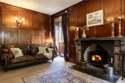 a living room with a couch and a fireplace at Large Grade II Listed House & Garden nr Beaches in Saint Columb Major