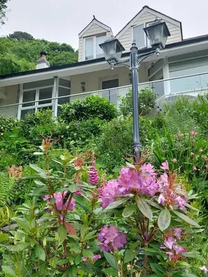a street light and flowers in front of a house at Cosy Home on the Waterfront Private Parking in Looe