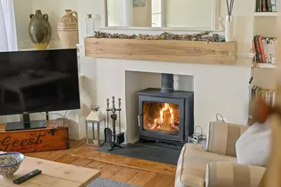 a living room with a fireplace and a tv at Cosy Home on the Waterfront Private Parking in Looe