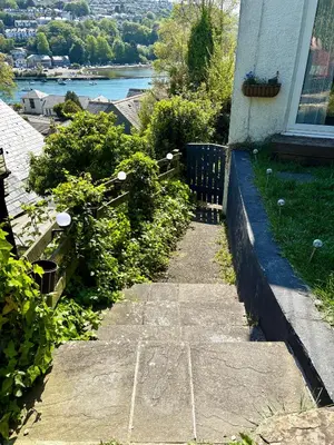 a garden path leading to a house with a view of a river at The Fishermans Daughters in Looe