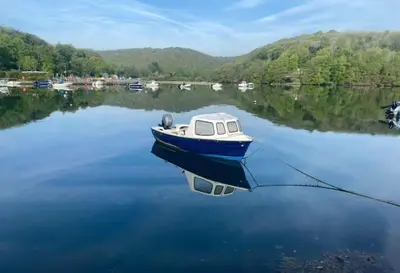 a small boat sitting on a body of water at The Fishermans Daughters in Looe