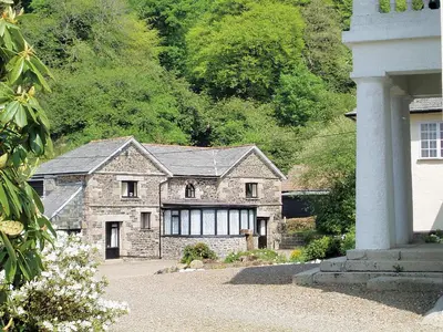 a large stone house in front of a mountain at Rosecraddoc Manor - Hayloft in Saint Cleer